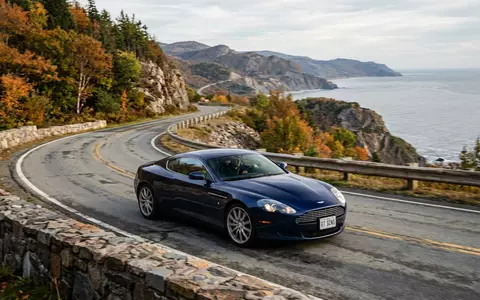 Fotorealistische Aufnahme von Sportcoupé auf der Landstraße zum Thema Aston Martin DB12, ISIN GB00BN7CG237 - Foto: THN