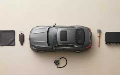 Flatlay-Arrangement rund um Sportcoupé zum Thema Aston Martin DB12, ISIN GB00BN7CG237, weiches Oberlicht - Foto: THN