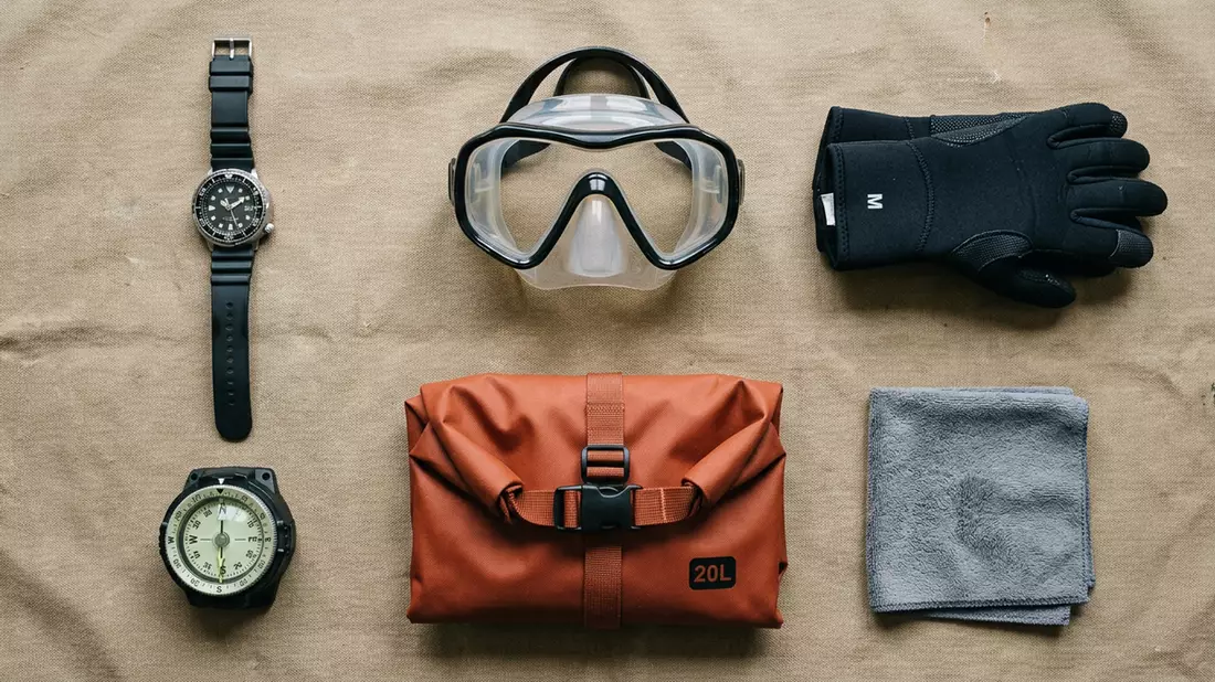 Flatlay-Arrangement rund um Taucheruhr mit passenden Requisiten von oben, neutral