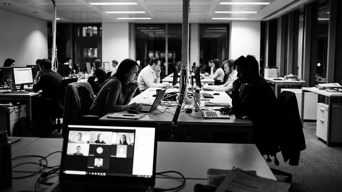 Schwarzweiss-Reportagebild mit Videokonferenz in dokumentarischer Arbeitsumgebung
