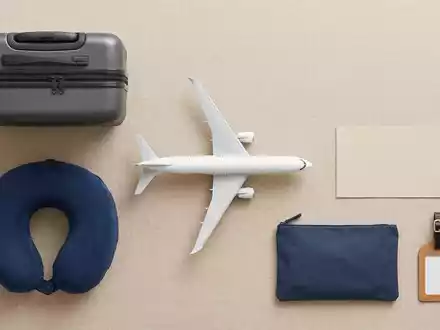 Flatlay-Arrangement rund um Passagierflugzeug zum Thema American Airlines Flug, ISIN US0010551028, weiches Oberlicht - Foto: THN