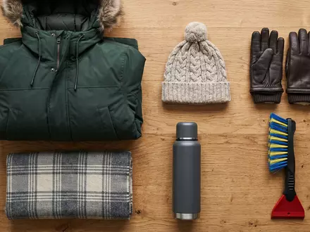 Flatlay-Arrangement rund um Winterparka zum Thema Canada Goose Parka, ISIN CA1350871028, weiches Oberlicht - Foto: THN