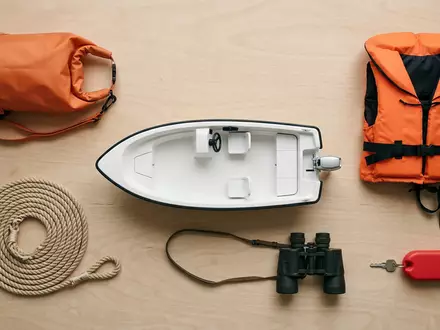 Flatlay-Arrangement rund um Motorboot zum Thema Sea Ray Boot, ISIN US1170431092, weiches Oberlicht - Foto: THN