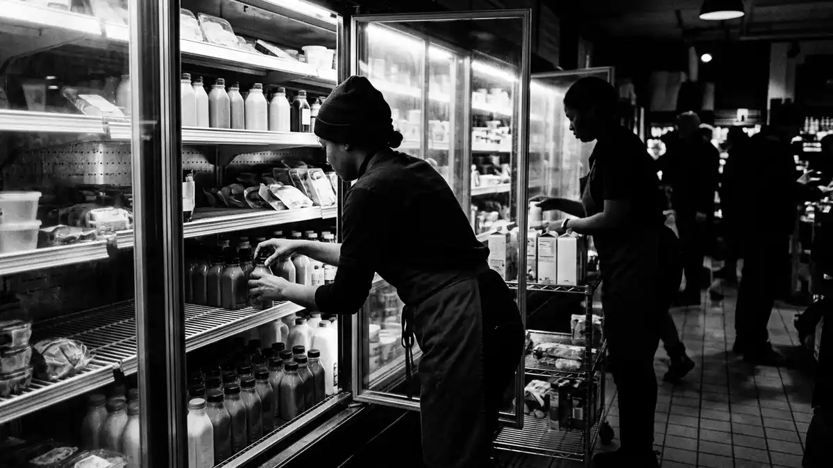 Schwarzweiss-Reportagebild mit Trinkjoghurt in dokumentarischer Arbeitsumgebung