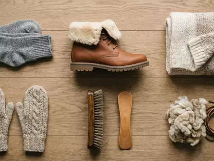 Flatlay-Arrangement rund um Stiefelette zum Thema UGG Classic Mini, ISIN US2435371073, weiches Oberlicht - Foto: THN