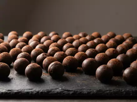 Fotorealistische Studioaufnahme von Schokoladentrüffel zum Thema Lindt Lindor Kugeln, ISIN CH0010570759, klare Lichtfuehrung - Foto: THN