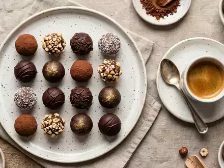 Flatlay-Arrangement rund um Schokoladentrüffel zum Thema Lindt Lindor Kugeln, ISIN CH0010570759, weiches Oberlicht - Foto: THN