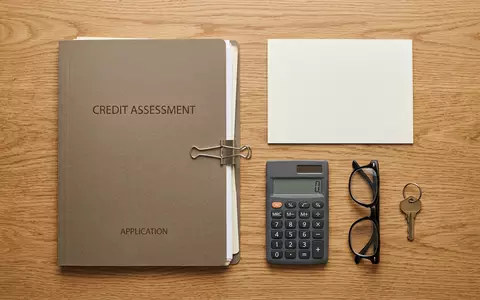 Flatlay-Arrangement rund um Bonitätsmappe zum Thema Equifax Bonitätsprüfung, ISIN US29444U7000, weiches Oberlicht - Foto: THN
