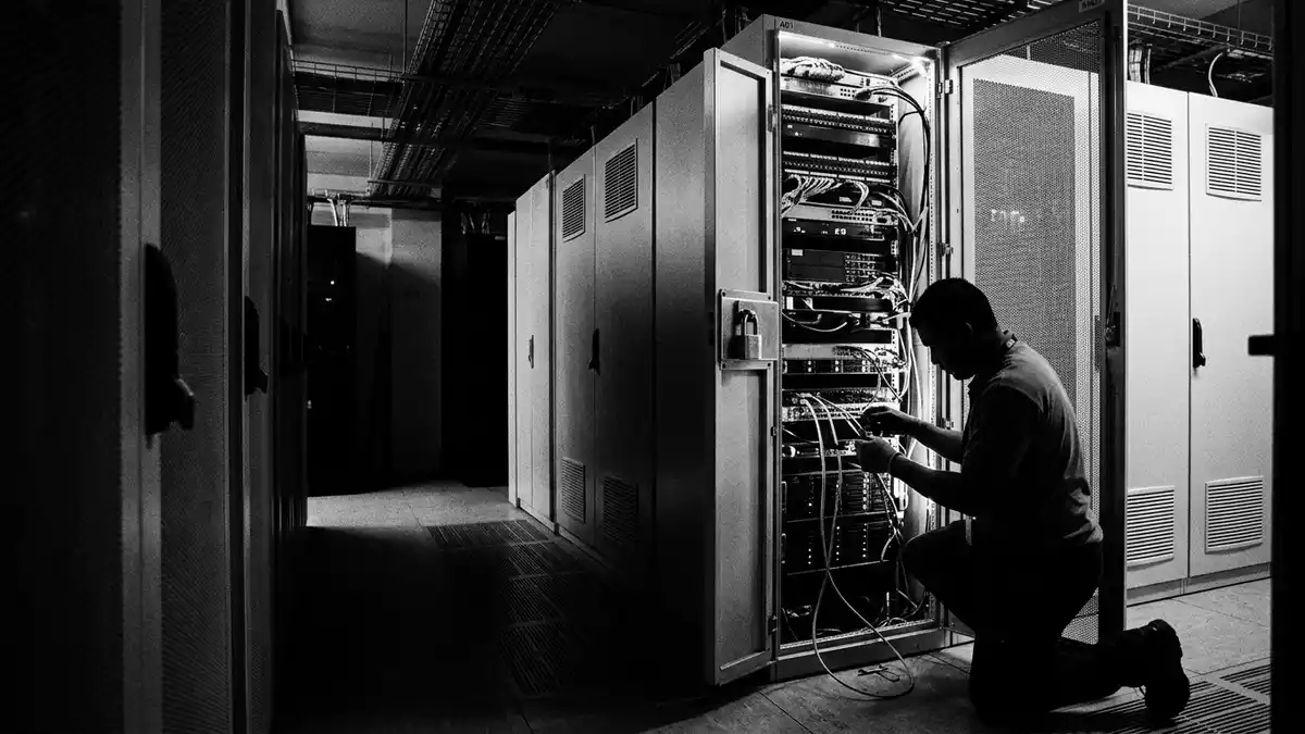 Schwarzweiss-Reportagebild mit Serverschrank in dokumentarischer Arbeitsumgebung