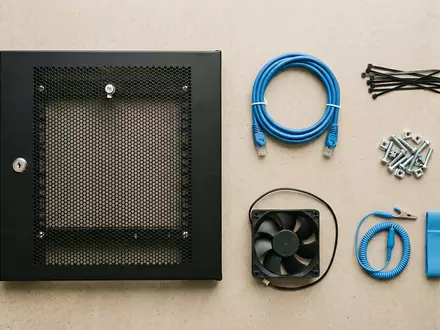 Flatlay-Arrangement rund um Serverschrank zum Thema Server Housing, ISIN US29476L1070, weiches Oberlicht - Foto: THN