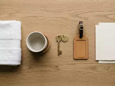 Flatlay-Arrangement rund um Hotelzimmer zum Thema Hilton Hotel, ISIN US43300A2033, weiches Oberlicht - Foto: THN