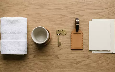 Flatlay-Arrangement rund um Hotelzimmer zum Thema Hilton Hotel, ISIN US43300A2033, weiches Oberlicht - Foto: THN