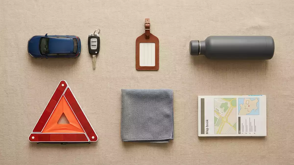 Flatlay-Arrangement rund um Mietwagen mit passenden Requisiten von oben, neutral