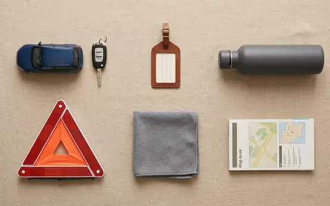 Flatlay-Arrangement rund um Mietwagen zum Thema Hertz Mietwagen, ISIN US42809H1077, weiches Oberlicht - Foto: THN