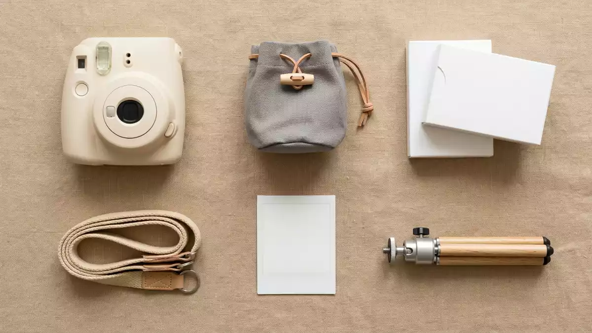 Flatlay-Arrangement rund um Sofortbildkamera mit passenden Requisiten von oben