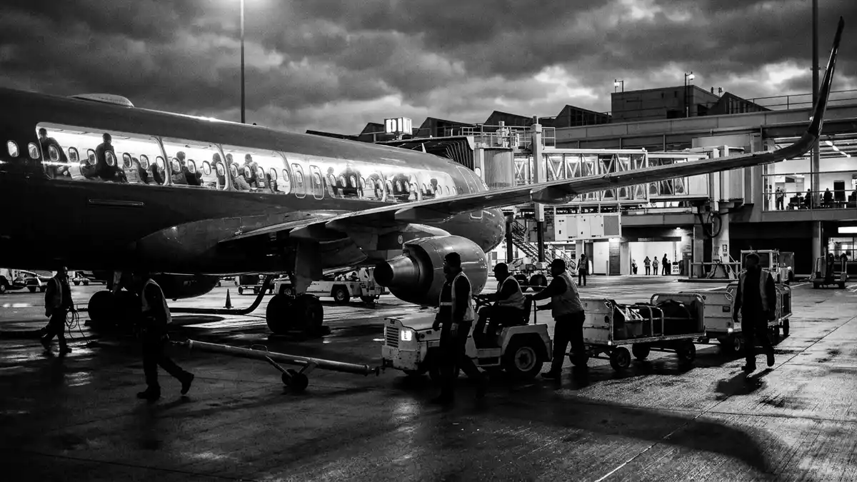 Schwarzweiss-Reportagebild mit Passagierflugzeug in dokumentarischer Arbeitsumgebung