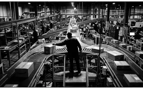 Schwarzweiss-Reportage mit Paketsortierung zum Thema Kühne+Nagel Tracking, ISIN CH0044328745, hoher Kontrast, sachlich dargestellt - Foto: THN