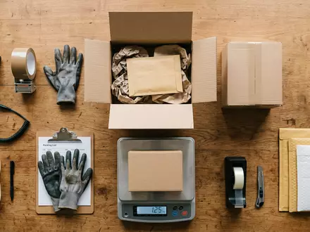 Flatlay-Arrangement rund um Paketsortierung zum Thema Kühne+Nagel Tracking, ISIN CH0044328745, weiches Oberlicht - Foto: THN