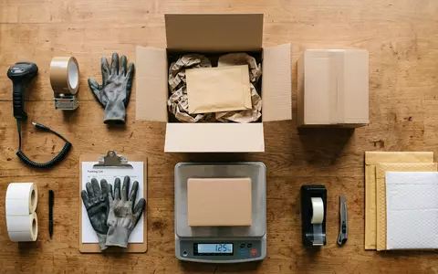 Flatlay-Arrangement rund um Paketsortierung zum Thema Kühne+Nagel Tracking, ISIN CH0044328745, weiches Oberlicht - Foto: THN