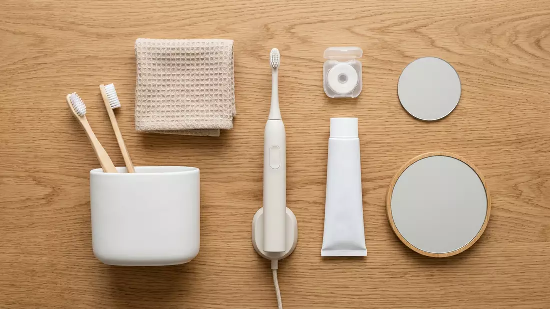 Flatlay-Arrangement rund um Elektrozahnbürste mit passenden Requisiten von oben