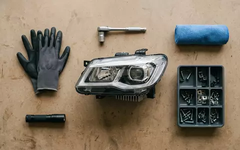Flatlay-Arrangement rund um Autoscheinwerfer zum Thema Hella Scheinwerfer, ISIN DE000A13SX22, weiches Oberlicht - Foto: THN
