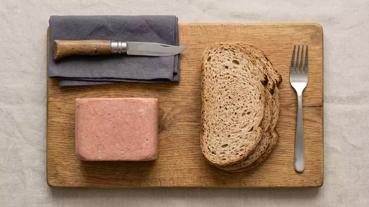 Flatlay-Arrangement rund um Dosenfleisch mit passenden Requisiten von oben, neutral