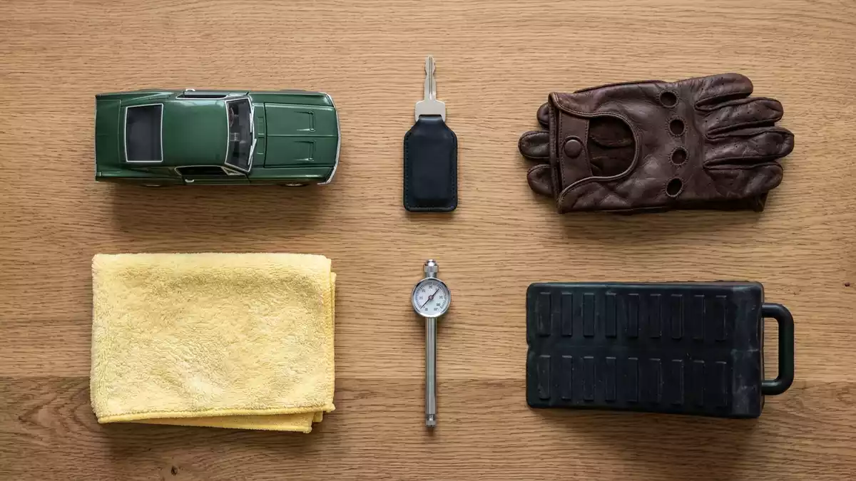 Flatlay-Arrangement rund um Sportcoupé mit passenden Requisiten von oben, neutral