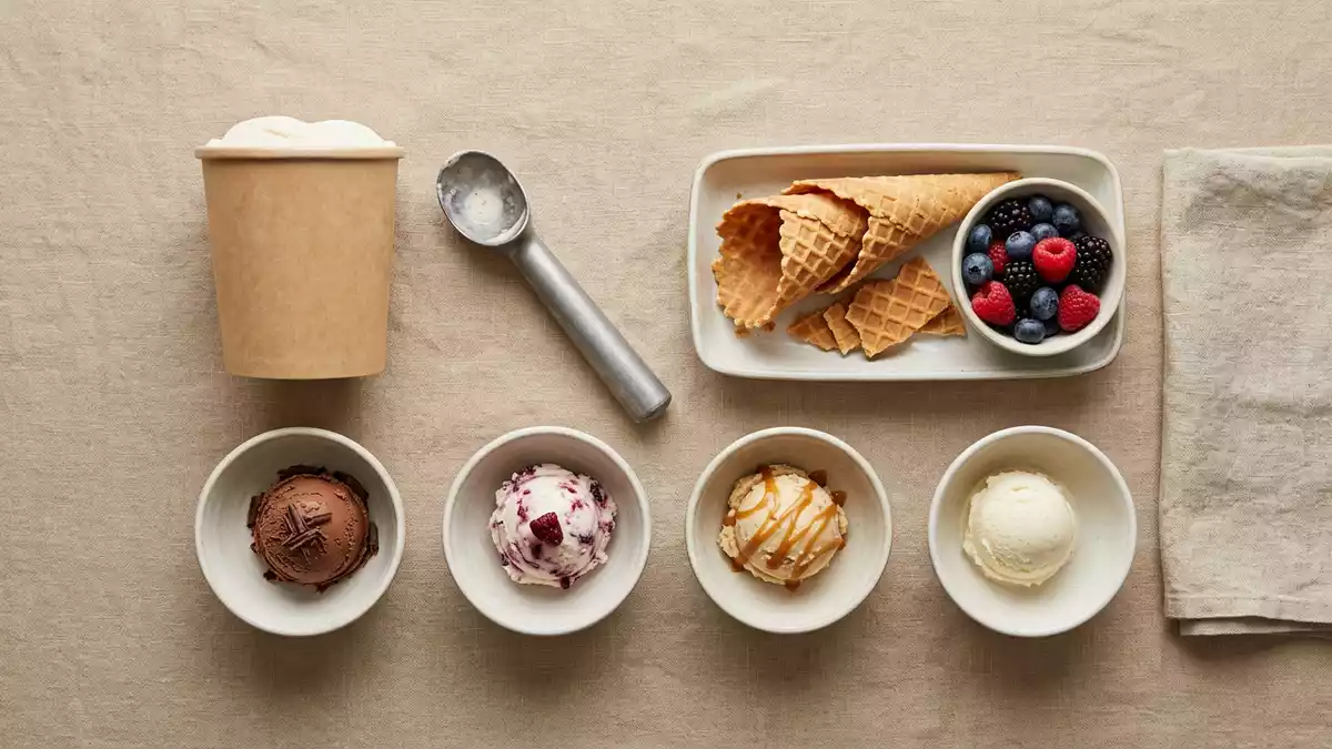 Flatlay-Arrangement rund um Speiseeis mit passenden Requisiten von oben, neutral