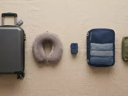 Flatlay-Arrangement rund um Handgepäckkoffer zum Thema easyJet Flug, ISIN GB00B7KR2P84, weiches Oberlicht - Foto: THN