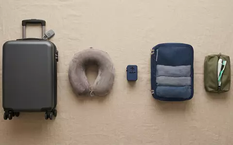Flatlay-Arrangement rund um Handgepäckkoffer zum Thema easyJet Flug, ISIN GB00B7KR2P84, weiches Oberlicht - Foto: THN