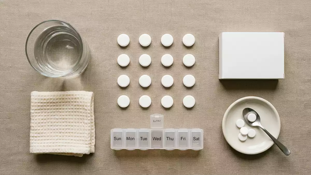 Flatlay-Arrangement rund um Schmerztabletten mit passenden Requisiten von oben