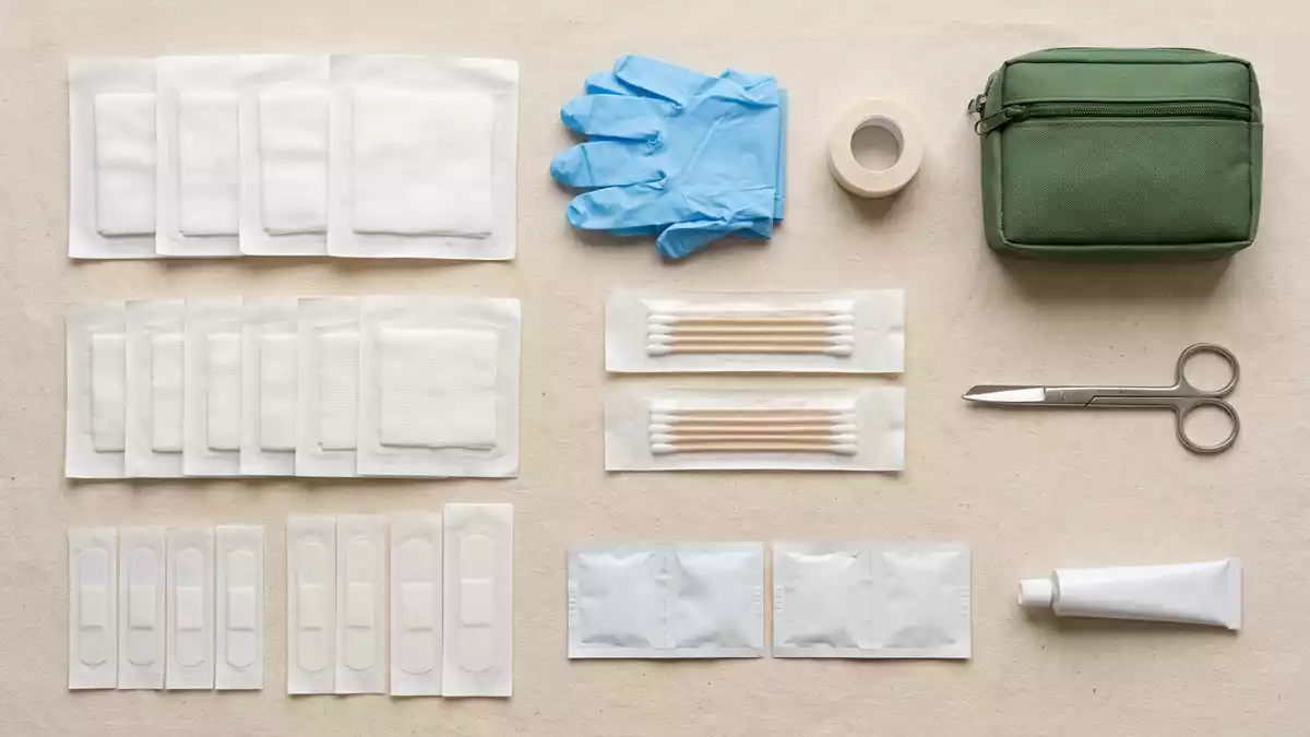 Flatlay-Arrangement rund um Wundverband mit passenden Requisiten von oben, neutral