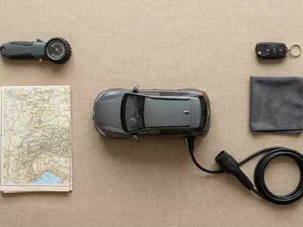 Flatlay-Arrangement rund um Elektro-SUV zum Thema Mercedes EQA, ISIN DE0007100000, weiches Oberlicht - Foto: THN