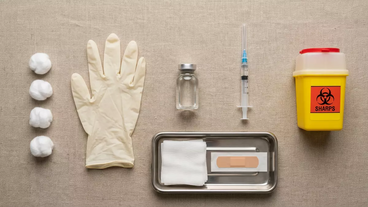 Flatlay-Arrangement rund um Impfstoffampulle mit passenden Requisiten von oben