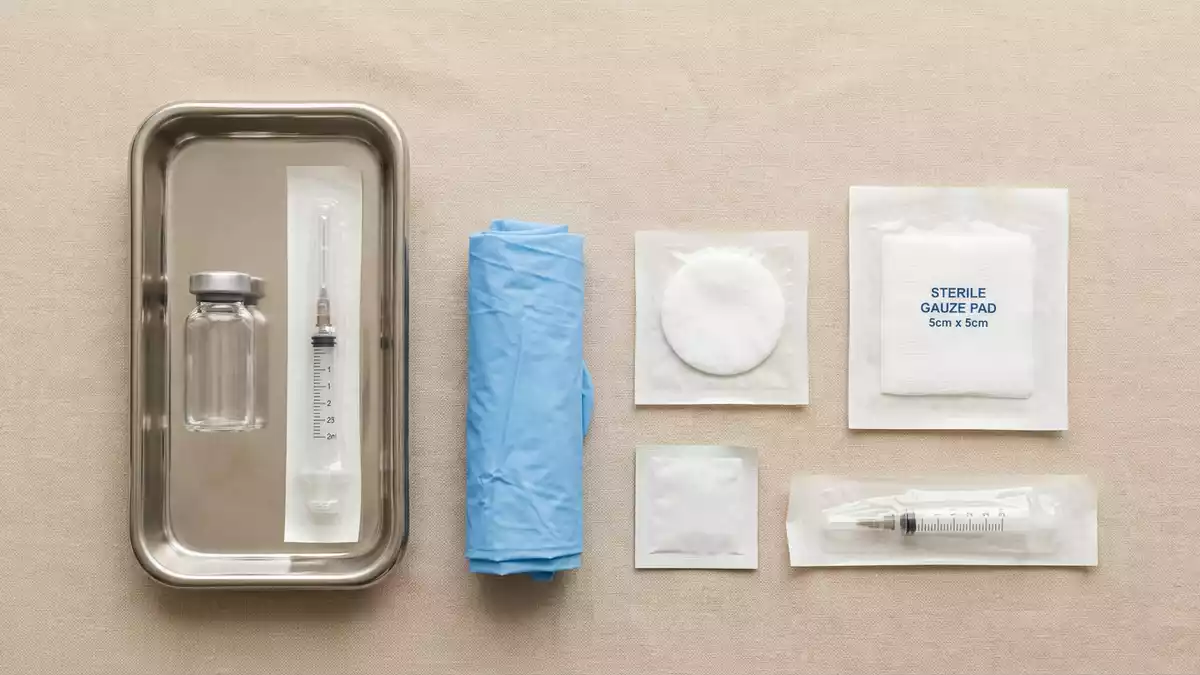 Flatlay-Arrangement rund um Impfstoffampulle mit passenden Requisiten von oben