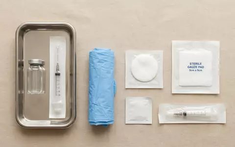 Flatlay-Arrangement rund um Impfstoffampulle zum Thema Pfizer Impfstoff, ISIN US7170811035, weiches Oberlicht - Foto: THN