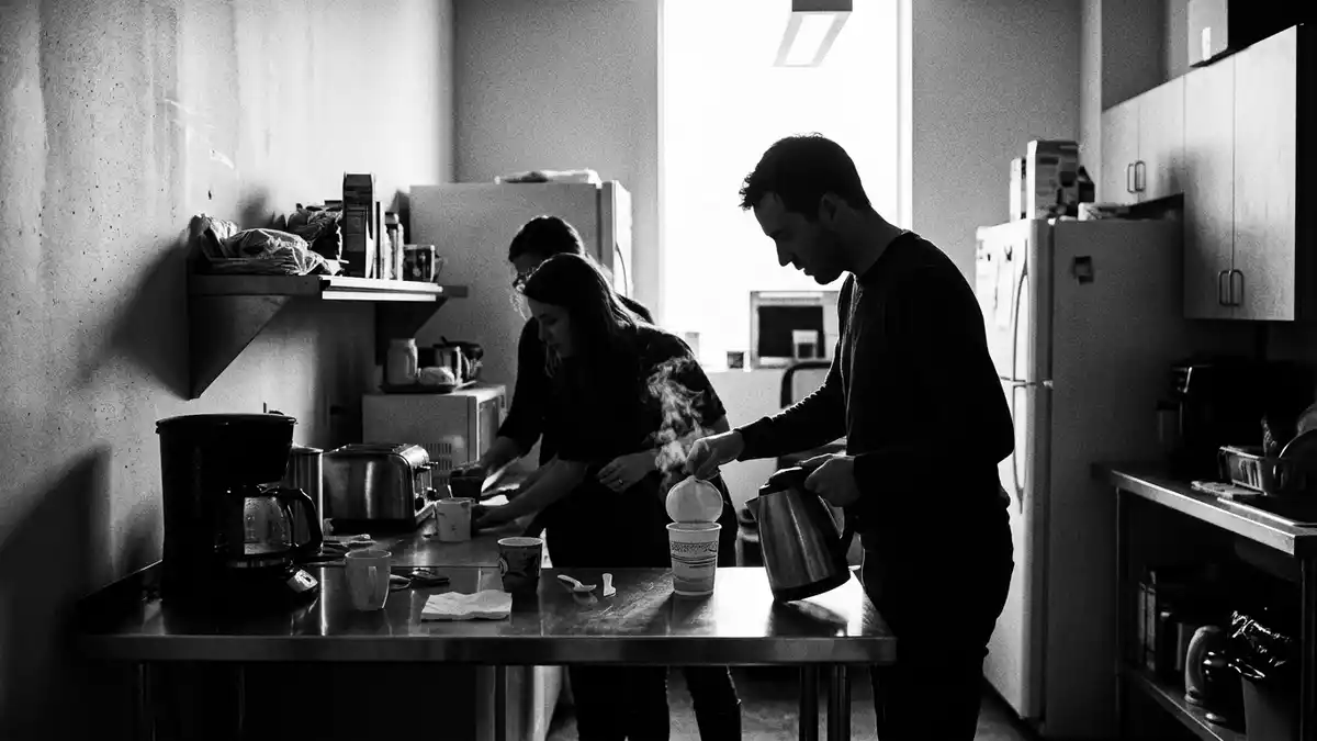 Schwarzweiss-Reportagebild mit Instant-Suppenbecher in dokumentarischer Arbeitsumgebung