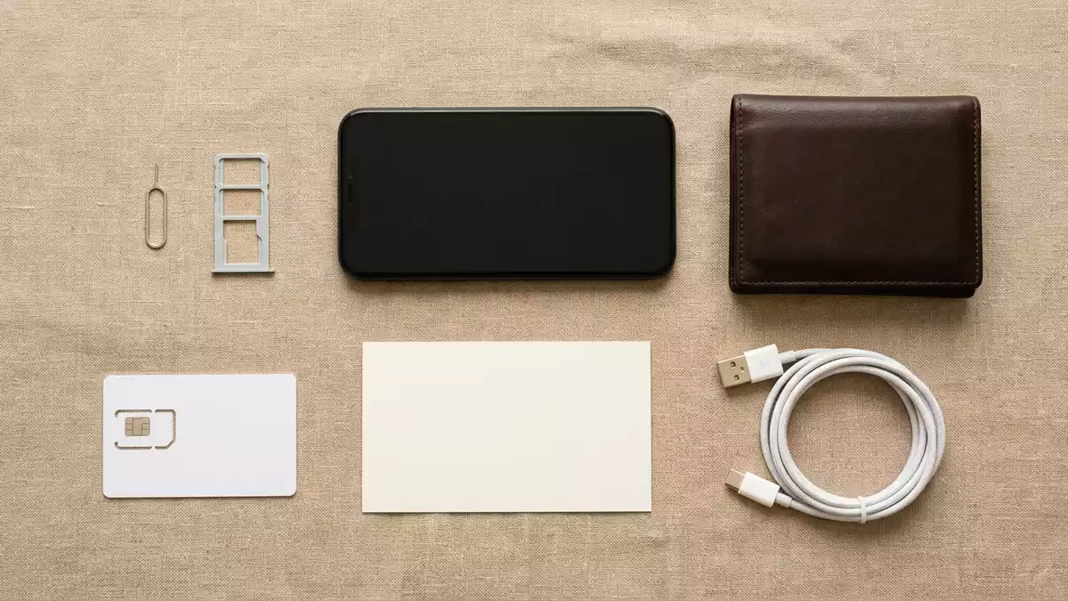 Flatlay-Arrangement rund um Reise-SIM-Karte mit passenden Requisiten von oben, neutral