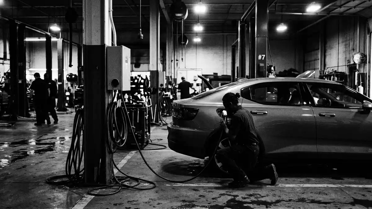 Schwarzweiss-Reportagebild mit Elektrolimousine in dokumentarischer Arbeitsumgebung