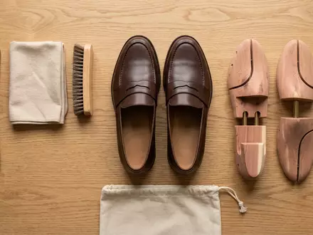 Flatlay-Arrangement rund um Lederloafer zum Thema Prada Loafers, ISIN HK0000096323, weiches Oberlicht - Foto: THN