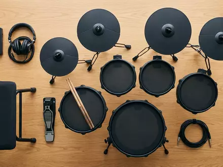 Flatlay-Arrangement rund um Elektronisches Schlagzeug zum Thema Roland E-Drums, ISIN JP3983400004, weiches Oberlicht - Foto: THN