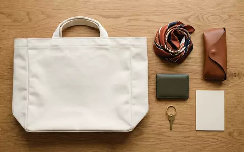 Flatlay-Arrangement rund um Stofftasche zum Thema Dior Book Tote, ISIN FR0000121014, weiches Oberlicht - Foto: THN