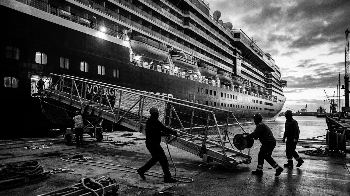 Schwarzweiss-Reportagebild mit Kreuzfahrtschiff in dokumentarischer Arbeitsumgebung