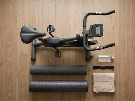 Flatlay-Arrangement rund um Heimtrainer zum Thema Peloton Bike, ISIN US7127131005, weiches Oberlicht - Foto: THN