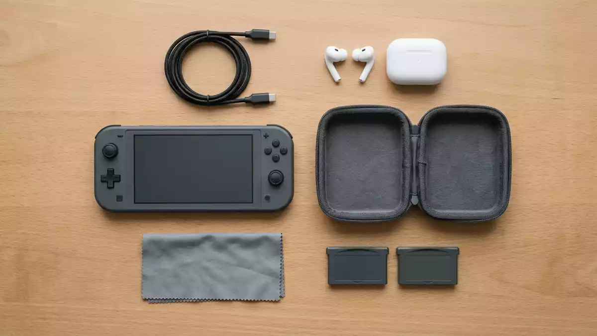Flatlay-Arrangement rund um Handheld-Konsole mit passenden Requisiten von oben