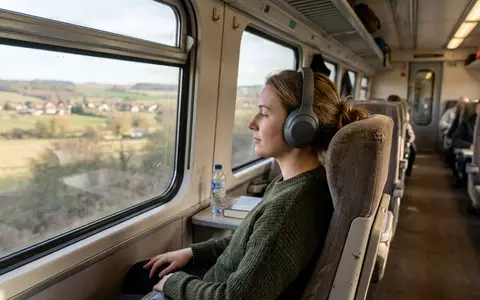Fotorealistische Aufnahme von Over-Ear-Kopfhörer auf Reisen zum Thema Sennheiser Momentum 4, ISIN CH0012549785, natuerliches Licht - Foto: THN