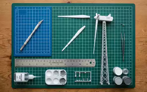 Flatlay-Arrangement rund um Windradmodell zum Thema Vestas Windrad, ISIN DK0010268606, weiches Oberlicht - Foto: THN