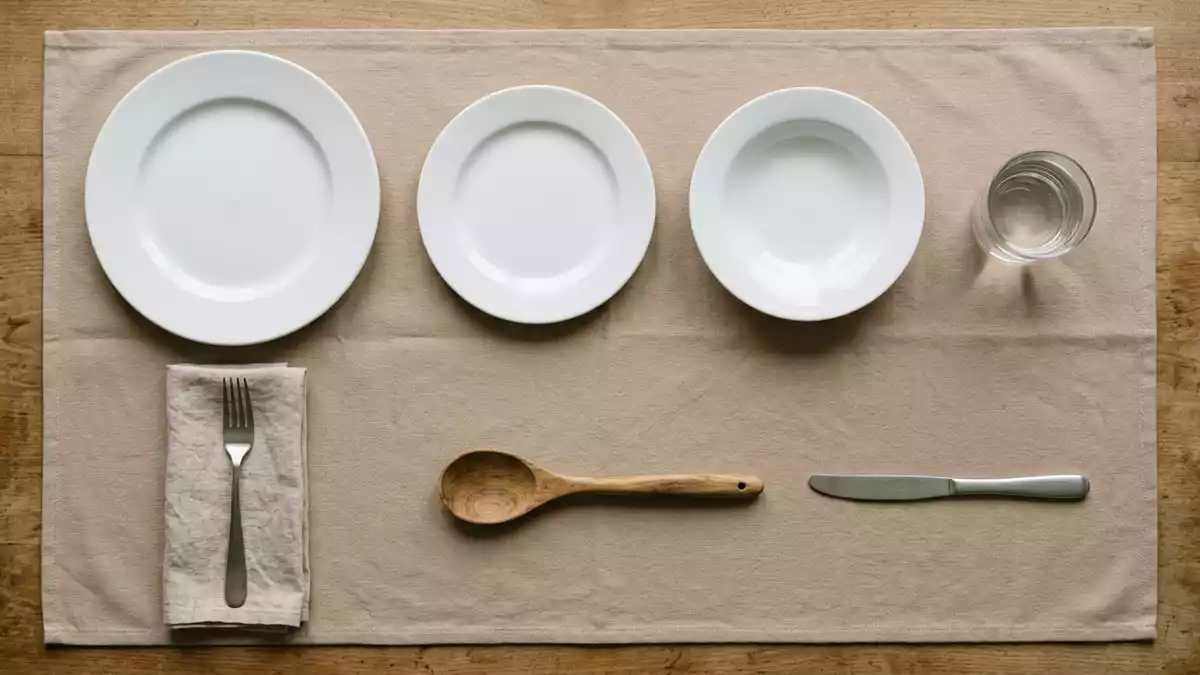Flatlay-Arrangement rund um Tafelgeschirr mit passenden Requisiten von oben, neutral