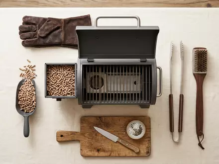 Flatlay-Arrangement rund um Pelletgrill zum Thema Traeger Pelletgrill, ISIN US8926721064, weiches Oberlicht - Foto: THN