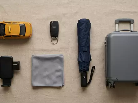 Flatlay-Arrangement rund um Taxifahrt zum Thema Uber Fahrt, ISIN US90353T1007, weiches Oberlicht - Foto: THN